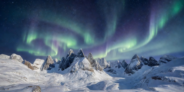 Clear night sky and auroral glow over the steep peaks of the Lyngen Alps in Norway