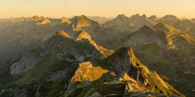 Golden midnight sun illuminating mountain ridges during Norwegian summer