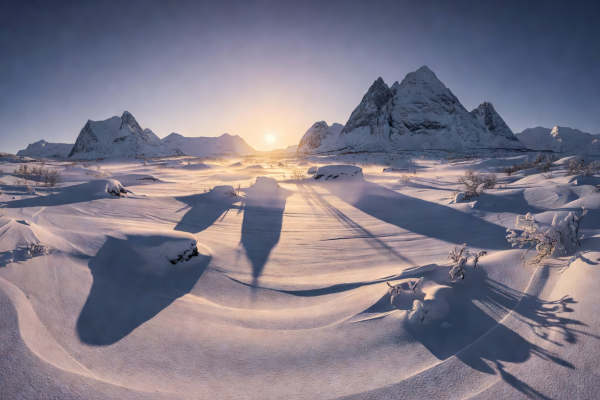 Low arctic winter sun creating dramatic long shadows across vast snow-covered Norwegian landscape
